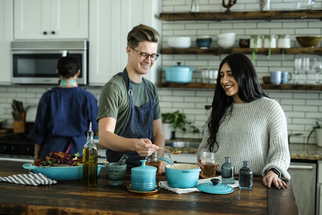 A support worker and a young woman cooking together at a kitchen counter